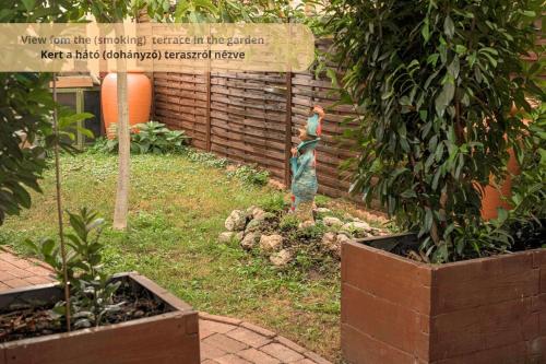 a statue of a woman standing in a garden at Tulip Home Guest House in Vác
