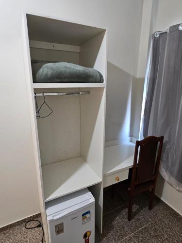 a white closet with a bed and a chair at HOTEL INDIANO in Rio Bonito