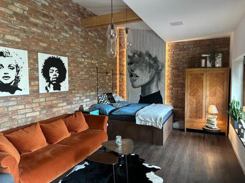 赫林斯科的住宿－Design apartmán v zahradě，带沙发和砖墙的客厅