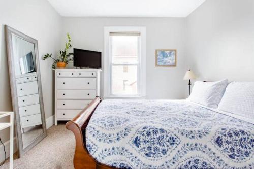 a bedroom with a bed and a dresser and a television at Queen Beds, Fast WiFi, Free Parking, Central A/C, TV's in New Haven