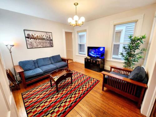 a living room with a blue couch and a tv at Queen Beds, Fast WiFi, Free Parking, Central A/C, TV's in New Haven
