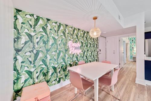a dining room with a white table and pink chairs at Beach Please condo 2 bedroom 2 bath sleeps 6 in Gulf Shores