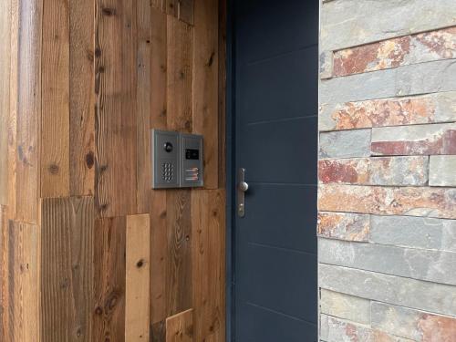 a wooden door with a metal box on a wall at Chez Gaston - Entrelacs in Pouilly