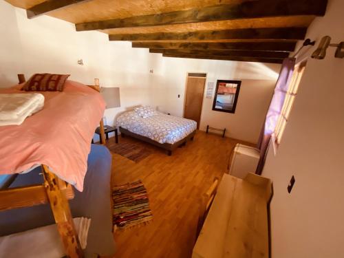 Habitación con vistas a un dormitorio con cama y sofá. en Atacama Checar, Hostal en San Pedro de Atacama