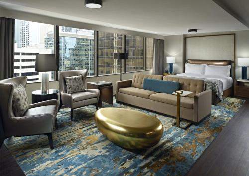 a hotel room with a bed and a couch and chair at Omni Charlotte Hotel in Charlotte