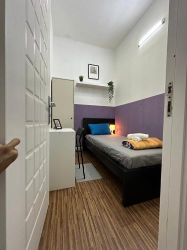 a bedroom with a bed with a purple wall at Prime Partition Room in Al Barsha 1 Near Metro in Dubai