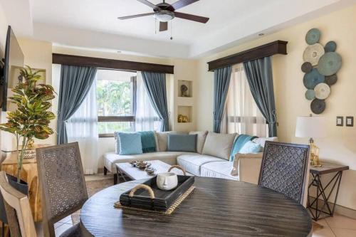 ein Wohnzimmer mit einem Tisch und einem Sofa in der Unterkunft The Oaks Tamarindo Pool Front Condominiums fast wifi in Tamarindo