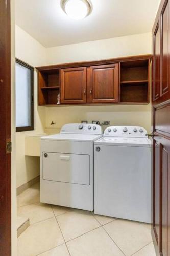 a kitchen with a washer and dryer in it at The Oaks Tamarindo Pool Front Condominiums fast wifi in Tamarindo