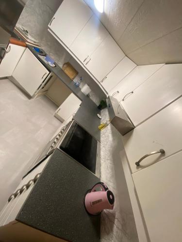 an overhead view of a kitchen with white cabinets at Lovely one bedroom apartment in Tromsø