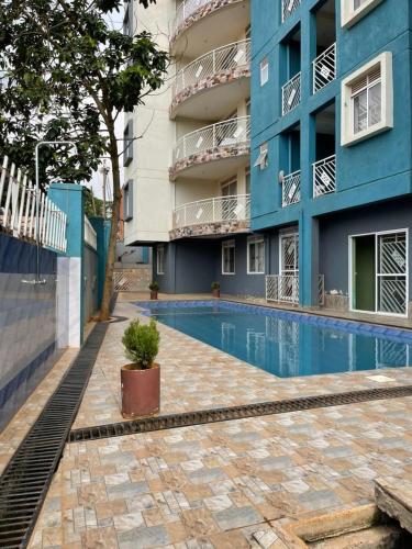 a swimming pool in front of a building at Cozy 1-Bed Apt with Pool & Gym in Najjera 2 in Kira