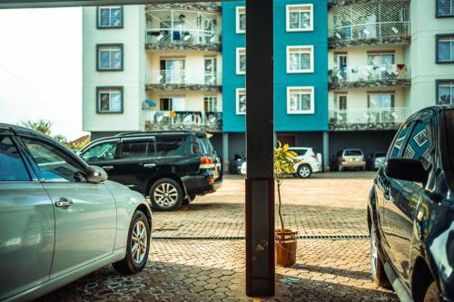 a group of cars parked in front of a building at Cozy 1-Bed Apt with Pool & Gym in Najjera 2 in Kira