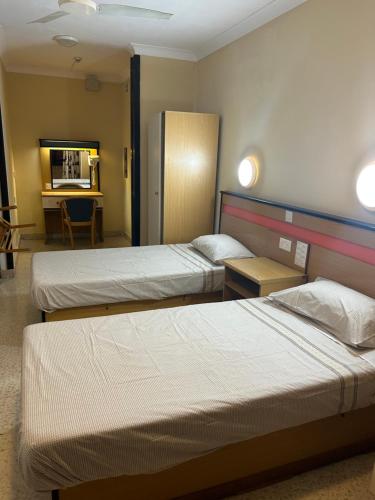 a hotel room with two beds and a table at EA holiday beds in St Julian's