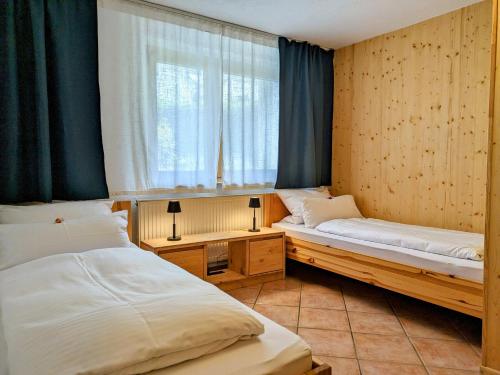 two beds in a room with a window and a window at Ferienwohnung am Hardtwald in Heidenheim an der Brenz