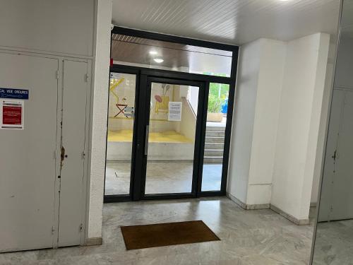 un accès à un bâtiment avec une porte en verre dans l'établissement Studio meublé près de la plage, à La Grande Motte