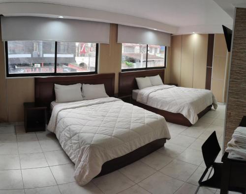a hotel room with two beds and two windows at HOTEL SAN THOMAS INN in Panama City