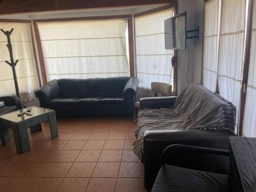 - un salon avec des canapés, une table et une télévision dans l'établissement Casa quinta Laguna La Brava La incoronata, à Villa Residencial Laguna Brava