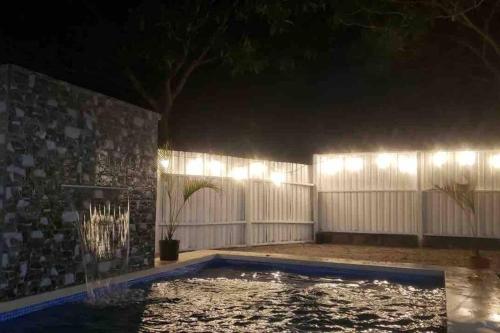 a swimming pool with lights in a backyard at night at La Quinta de Ita in Morales