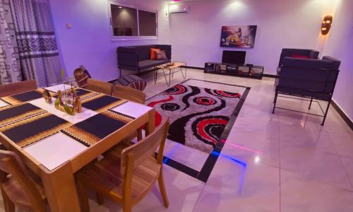 een eetkamer met een tafel en een tapijt bij Ngor Rooftop Terrace & Apartment in Dakar