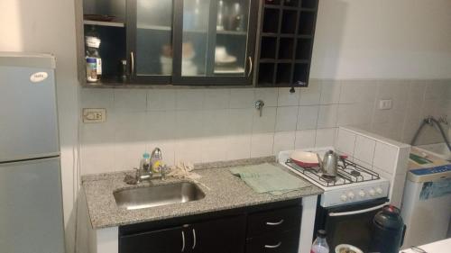 una piccola cucina con lavandino e piano cottura di Torres sarmiento un dormitorio a Resistencia