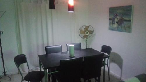 uma mesa de jantar com cadeiras e uma vela em Torres sarmiento un dormitorio em Resistência