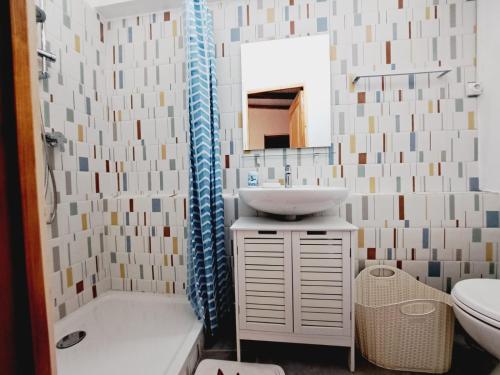 uma casa de banho com um lavatório, um WC e um espelho. em Kaz A Zette - vue mer et montagne em Saint-Claude