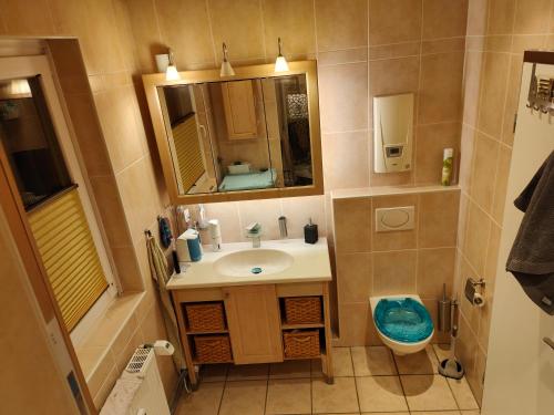 La salle de bains est pourvue d'un lavabo, de toilettes et d'un miroir. dans l'établissement Gästezimmer, à Hanovre