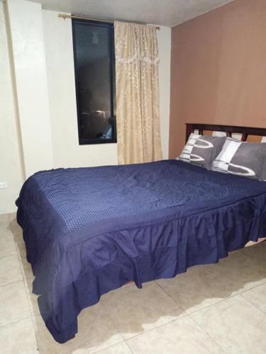 1 cama azul en un dormitorio con ventana en Hostal Restaurante el Fogón Campero, en Papallacta