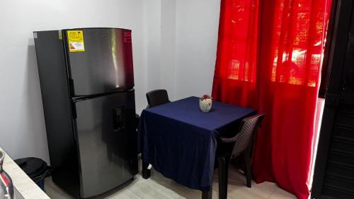 a table with a blue table cloth next to a refrigerator at EL EDÉN 102 in Puerto Triunfo
