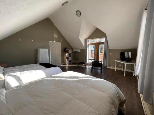 Mountain Magic في غولدن: غرفة نوم بسرير أبيض في العلية