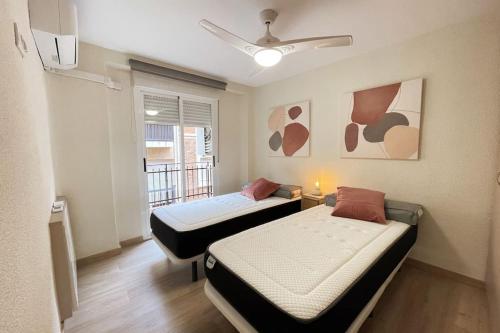 two beds in a small room with a window at Lemon & Blue -Céntrico-Nuevo-Grupos in Murcia