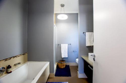 a bathroom with a large tub and a toilet at Seaforth Terrace in Simonʼs Town