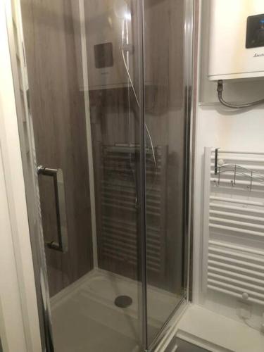 une douche avec une porte vitrée dans une salle de bain dans l'établissement Le Drakkar - Studio chaleureux *Parking *CLIM *Wifi 2 pers., à La Grande Motte