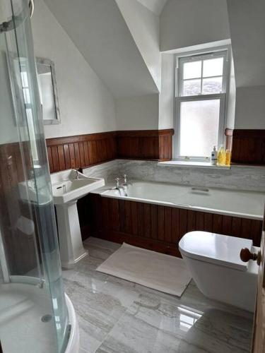 a bathroom with a tub and a toilet and a sink at 4 Caberfeidh in Fort William