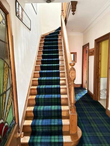 a spiral staircase in a house with a colorful carpet at 4 Caberfeidh in Fort William