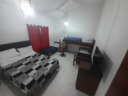 1 dormitorio con cama, escritorio y ordenador en La Martina en Villa Carlos Paz