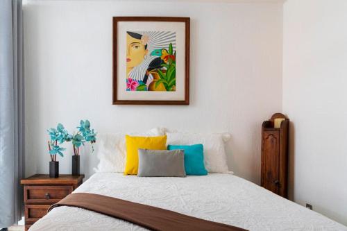 1 dormitorio con 1 cama con una foto en la pared en Casa AMAR·i·LLA Céntrica, en Guadalajara
