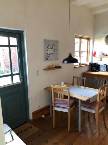 a kitchen with a table and chairs and a door at Ferienwohnung im Edelhof in Neustadt am Rübenberge