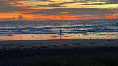 a person standing on the beach at sunset at The Grand Mango in El Gigante