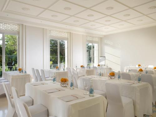 a white room with white tables and white chairs at Rumah Luwih Bali in Keramas