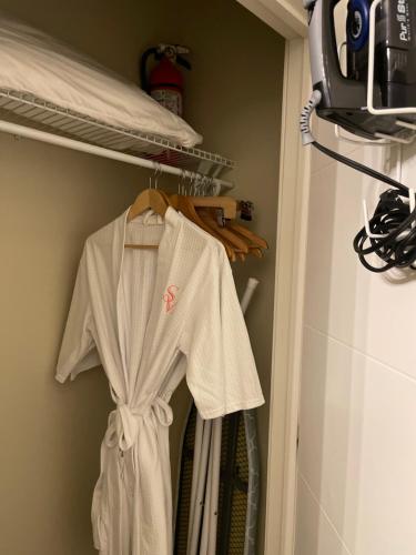 a white robe hanging on a rack in a closet at Serenity in the Marigny in New Orleans