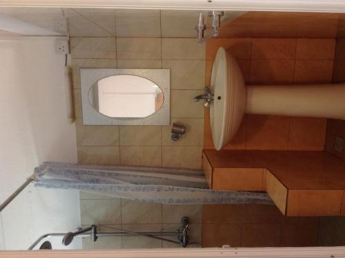a bathroom with a circular mirror and a sink at Ebrahim Flats - Grand Baie Beach in Grand Baie