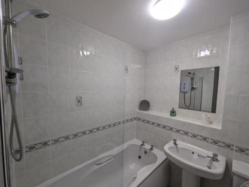 a bathroom with a tub and a sink and a bath tub at Great Location, large 1 bed flat with parking in Broughty Ferry