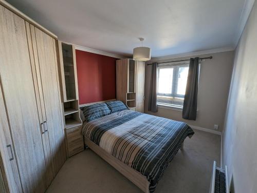 a small bedroom with a bed and a window at Great Location, large 1 bed flat with parking in Broughty Ferry