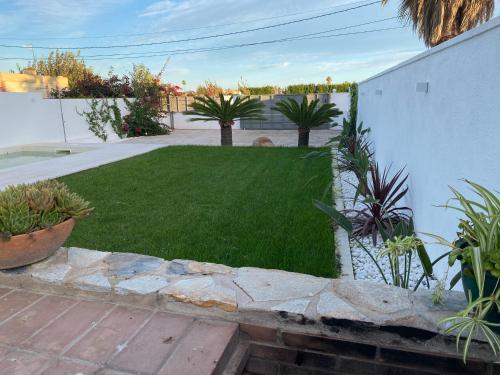 een kleine achtertuin met een tuin met gras en planten bij La Casa de Marieta "A" in Deltebre