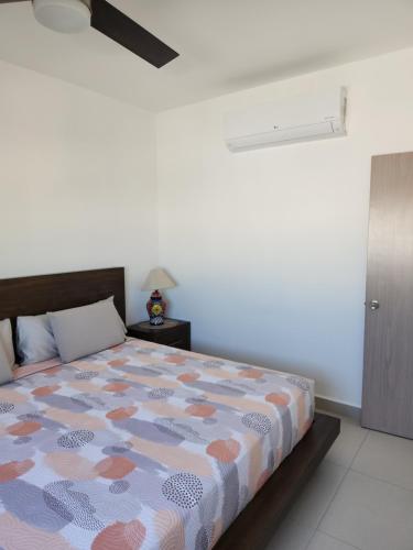 1 dormitorio con cama y pared blanca en Casa NUEVA ¡San José del Cabo! en San José del Cabo