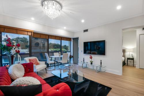 a living room with a red couch and a table at Your Next Viaduct Getaway! in Auckland