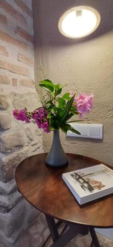 a vase with flowers sitting on a table at FeelhomeVIC. Ático con terraza en centro histórico in Vic