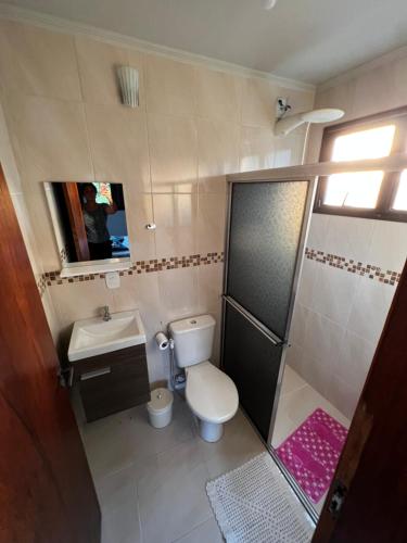 a small bathroom with a toilet and a sink at Apto Espaçoso no Centro de Ubatuba - 3 quartos, 2 vaga garagem,2 banheiros,Cozinha Completa in Ubatuba
