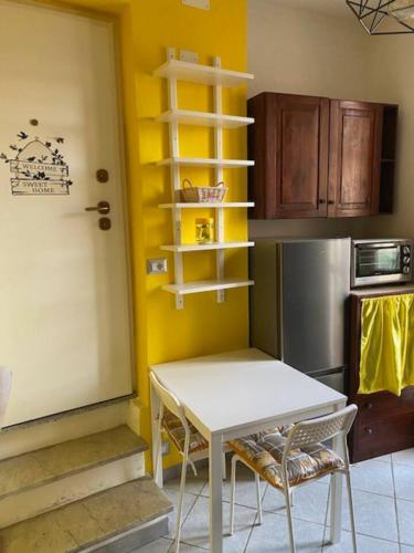 a kitchen with a table and chairs and a refrigerator at Lo scrigno dei nonni in Ovada