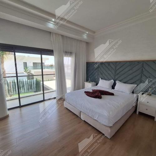 a bedroom with a white bed and a large window at Blue Haven Villa 4 bedroomTaghazout Bay Amda in Taghazout
